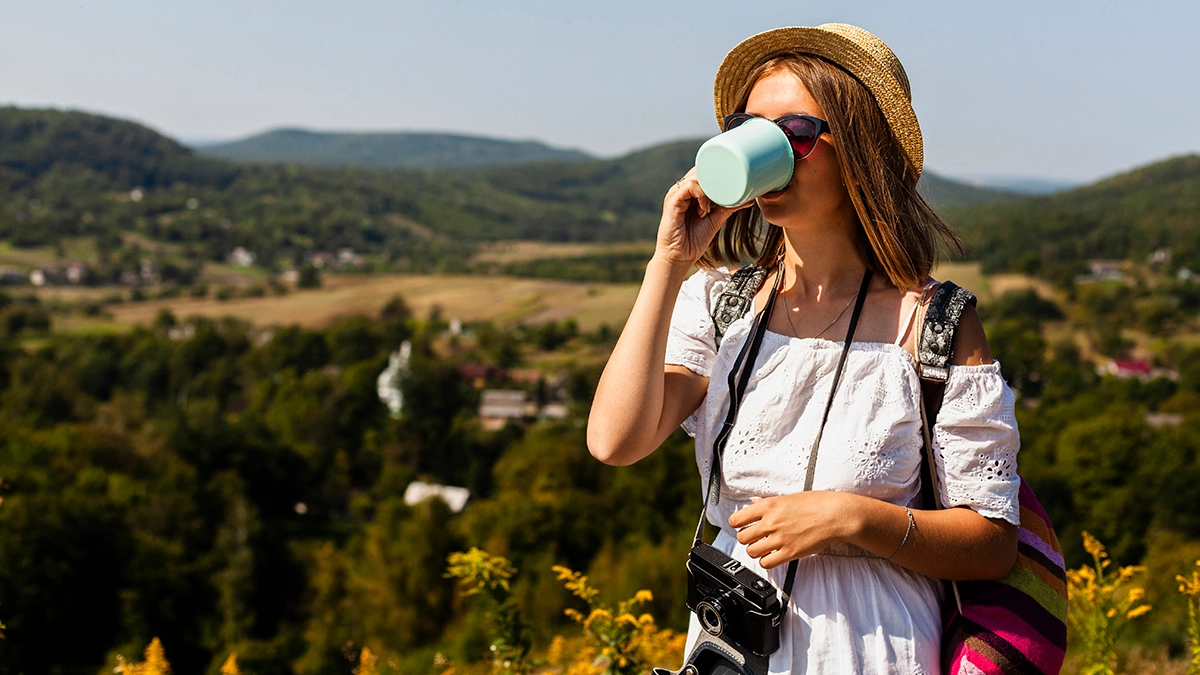 woman white dress drinking from cup